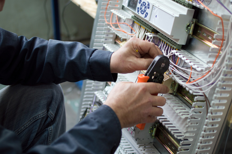 Electrician terminating wiring in a control panel