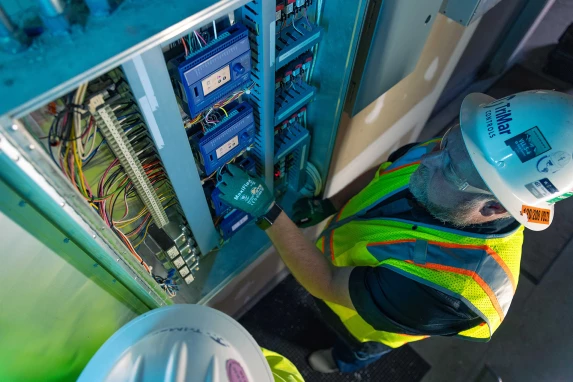 Technicians wiring a building automation control cabinet
