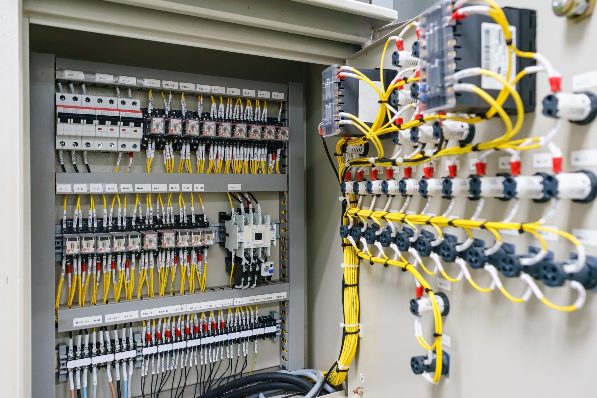 Industrial control panel with labeled relays, circuit breakers, and wiring